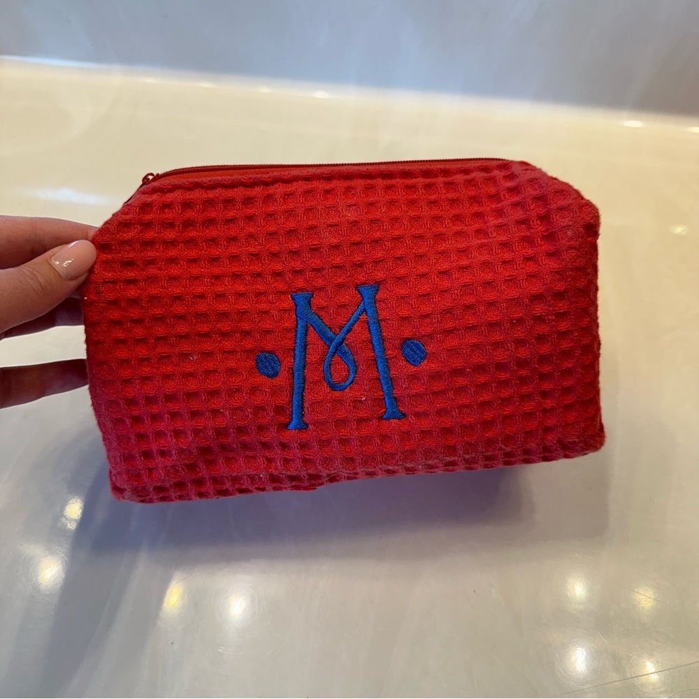 Red monogrammed “M” cosmetic pouch
